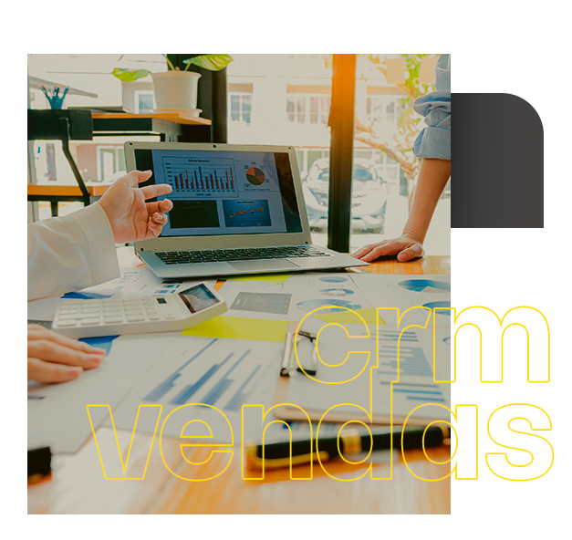 Uma pessoa está sentada em uma mesa com um laptop e um tablet. Consultoria e implementação de CRM e vendas