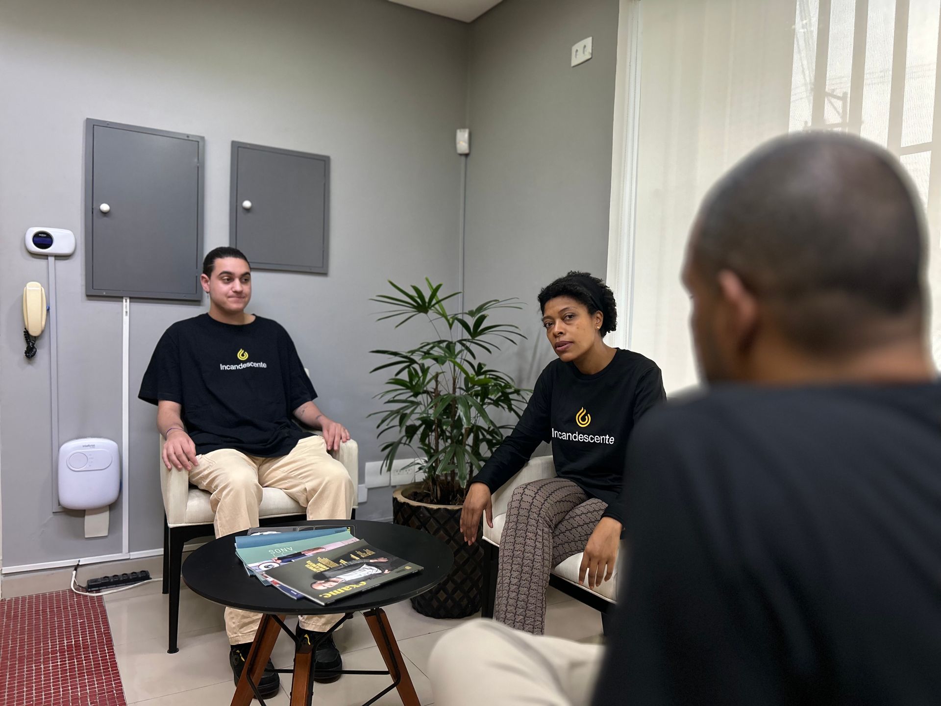 Um homem e uma mulher estão sentados em uma sala de estar conversando um com o outro.