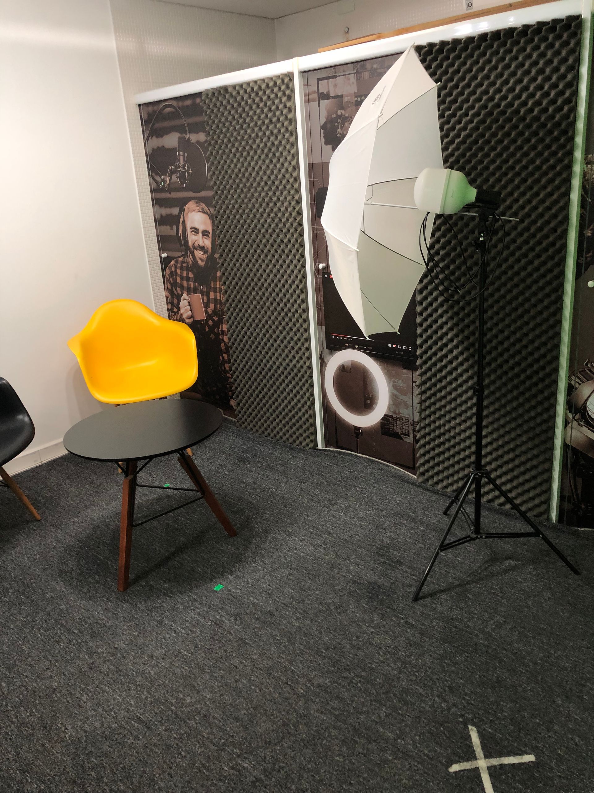 Uma sala com uma cadeira amarela, uma mesa e uma luz.