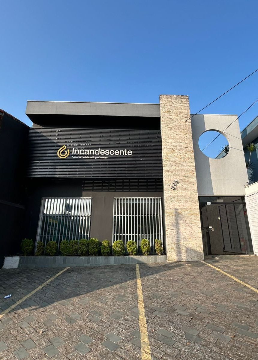 Um grande edifício com um estacionamento na frente.