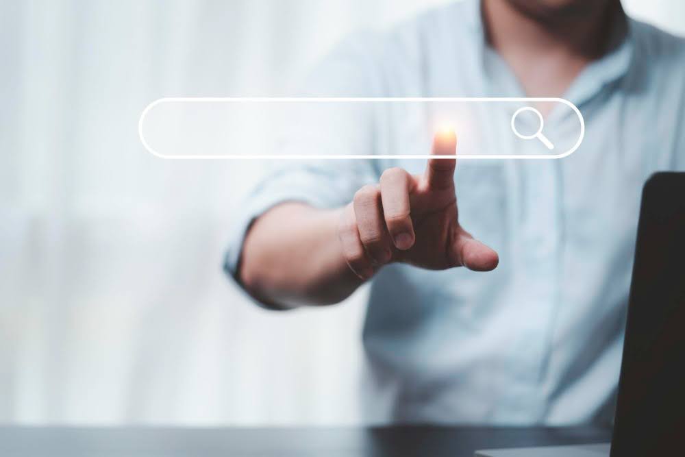 homem branco tocando no campo de buscas do Google