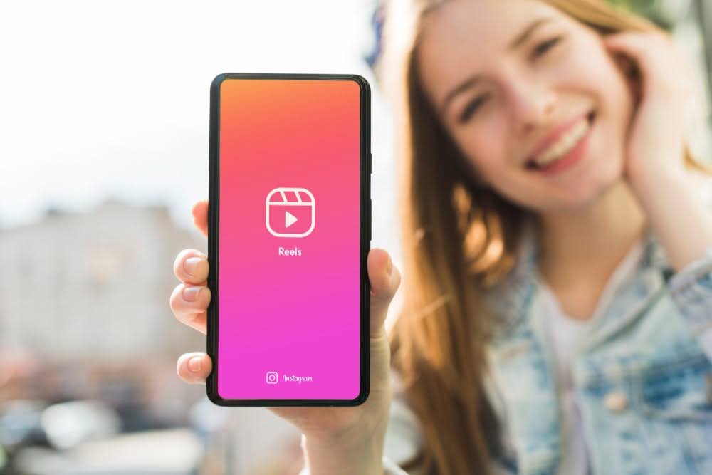 mulher mostrando reels na tela de um celular