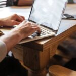 homem branco digitando em um notebook